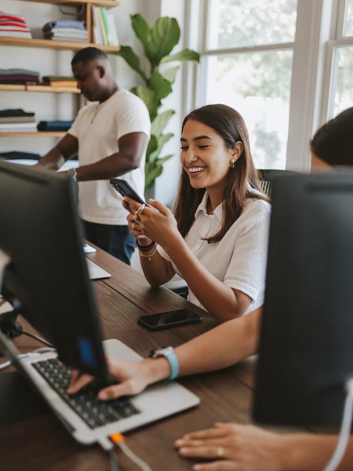 Equipe de uma loja atendendo clientes pelo celular e pelo computador